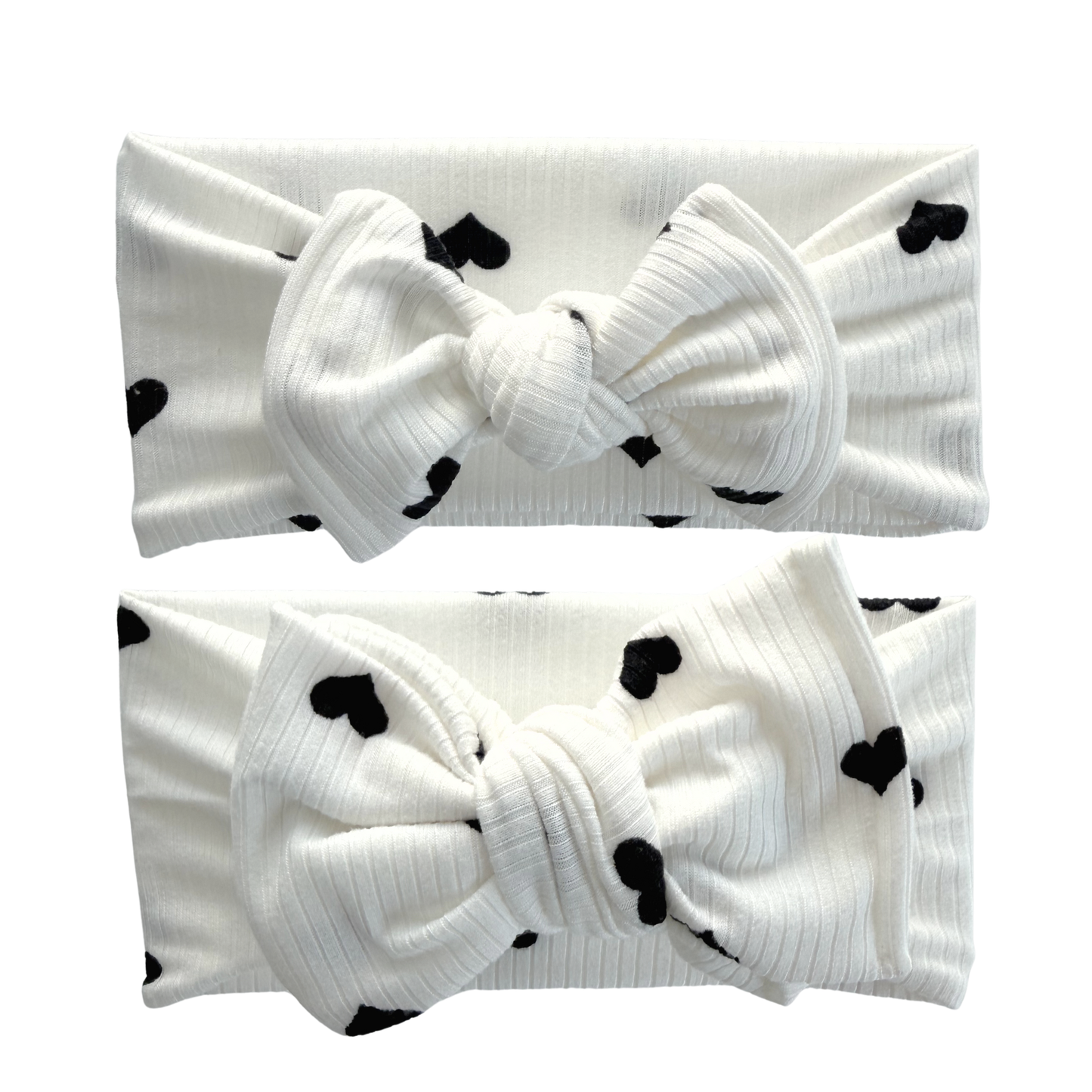 Two white headbands with black heart patterns on a white background. Top is a top knot, bottom is an oversized bow.