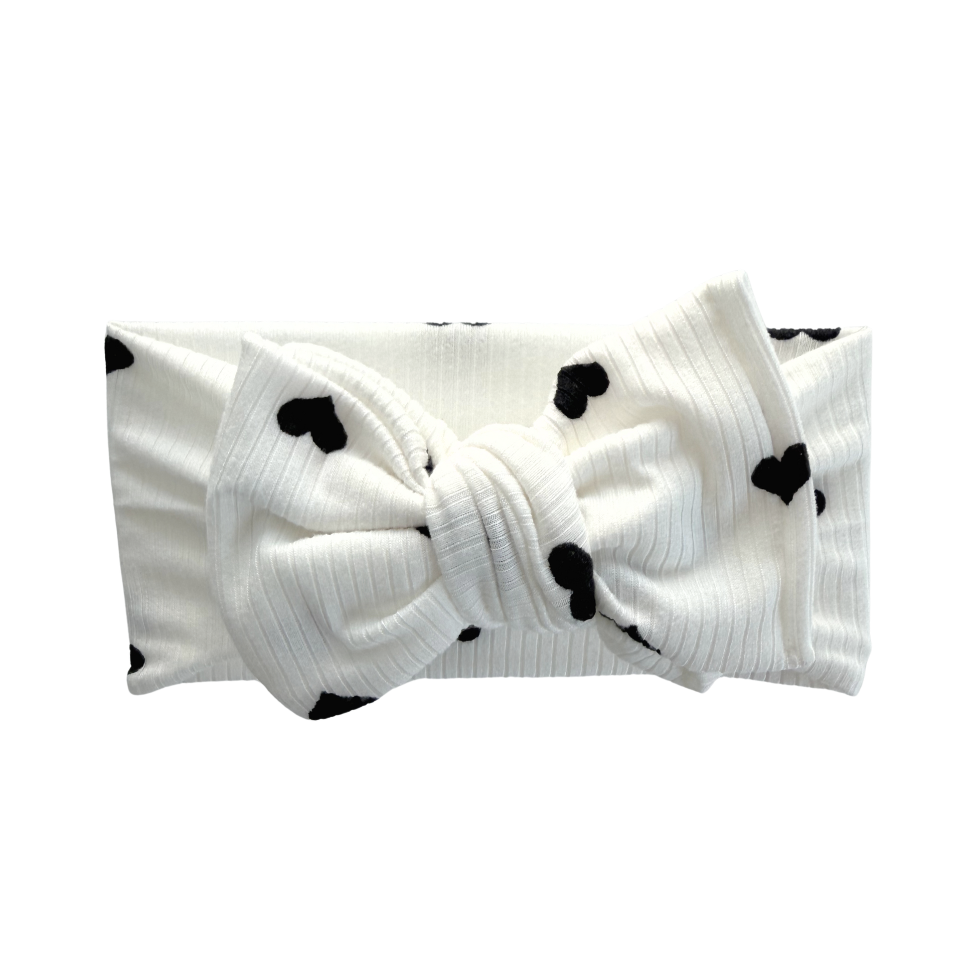 Ribbed white oversized bow headband with black heart print.