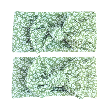 Two green floral headbands with bows on a white background
