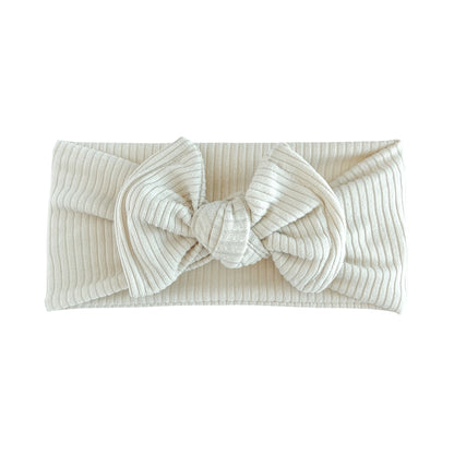 Sand beige ribbed top knot headband on a white background.