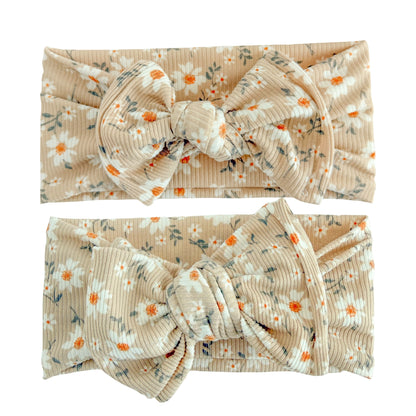 Baby girl headbands in top knot and oversized bow styles in taupe daisy floral print, made from ribbed knit fabric
