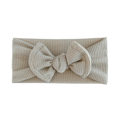 Top knot baby headband in taupe, crafted from waffle knit fabric, displayed on a white background