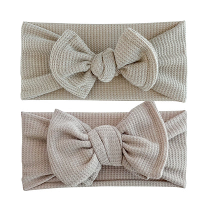 Baby girl headbands in top knot and oversized bow styles in taupe, made from waffle knit fabric
