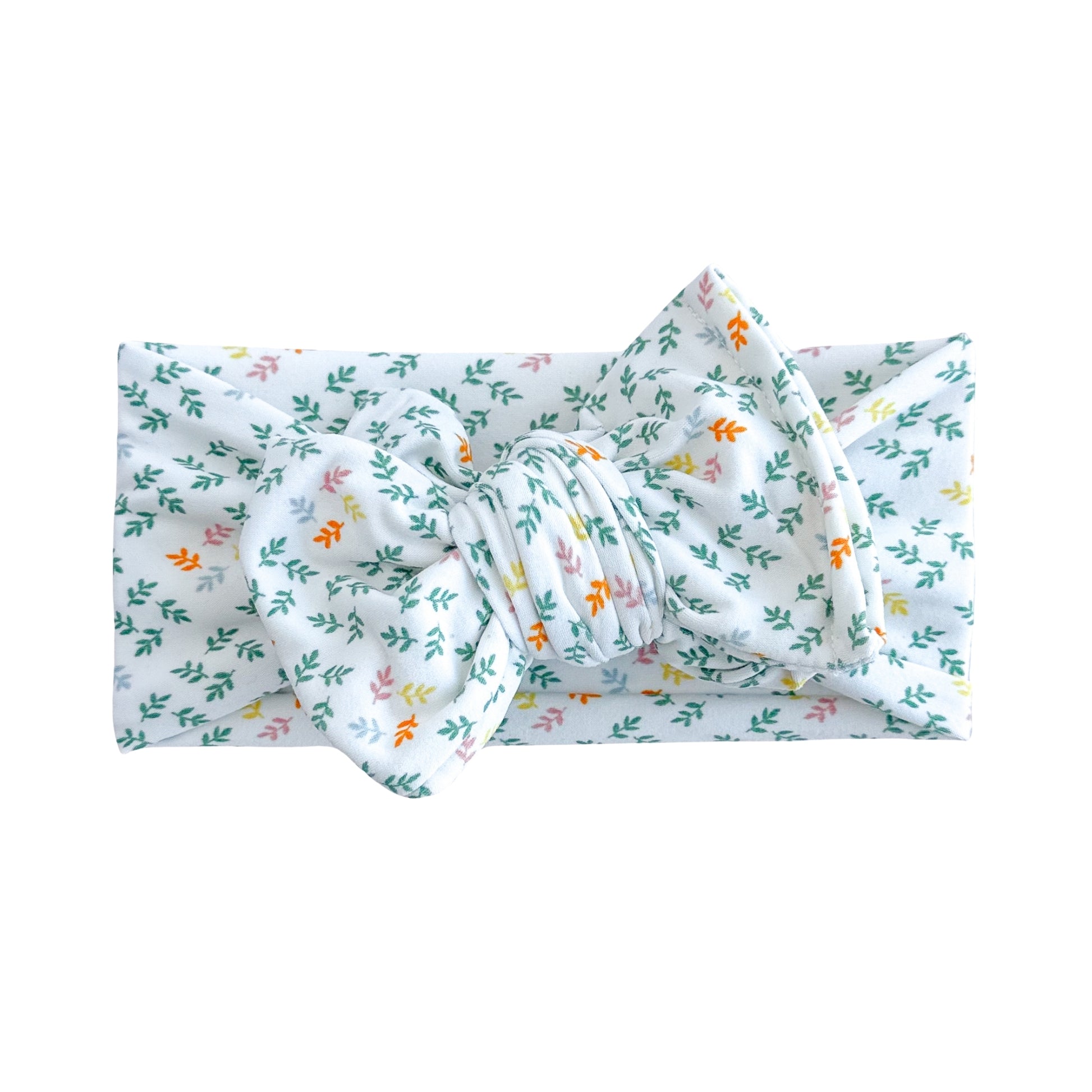 Oversized bow baby headband in white with teal botanical print, crafted from double brushed knit fabric, displayed on a white background