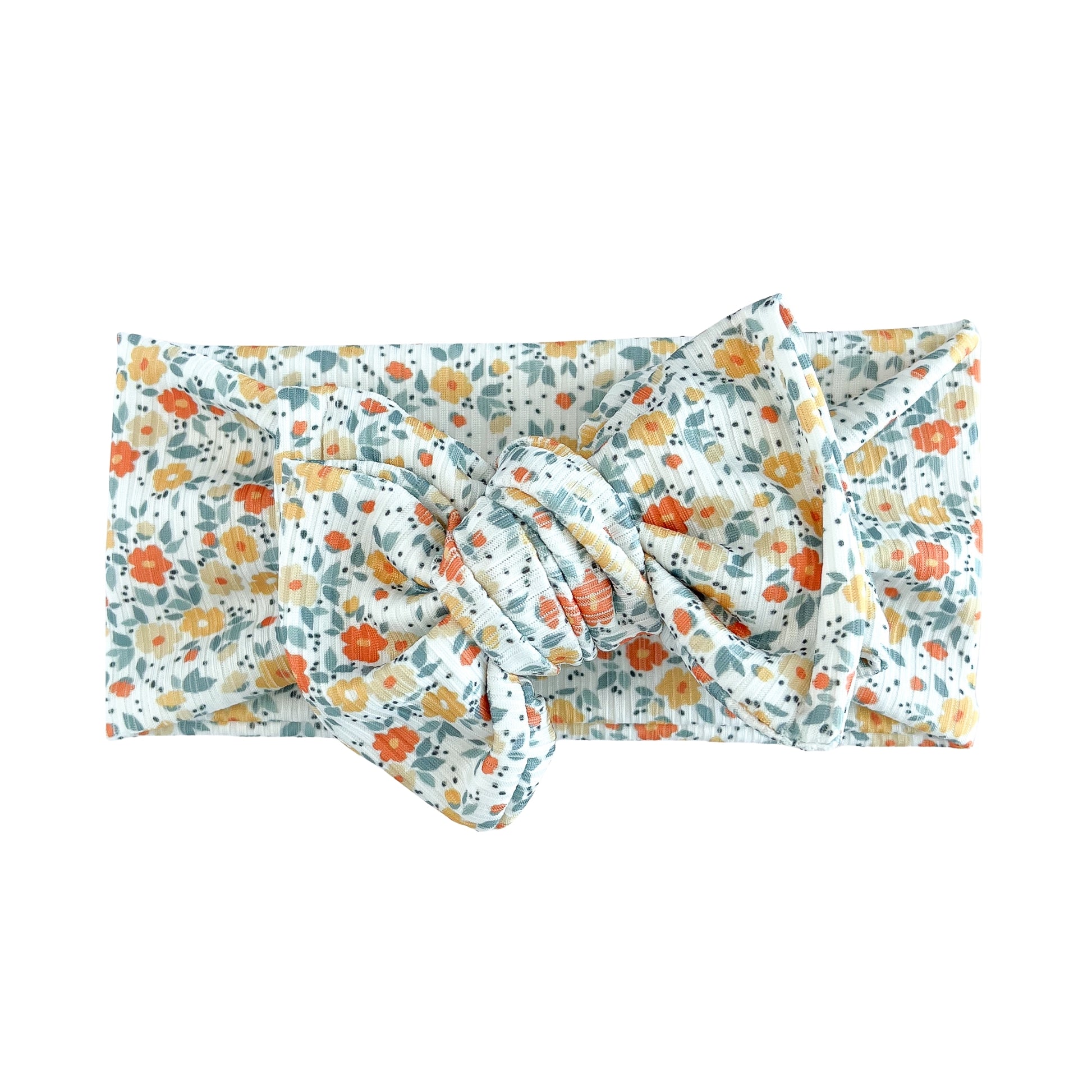 Top knot baby headband in blue vintage floral print, crafted from ribbed knit fabric, displayed on a white background