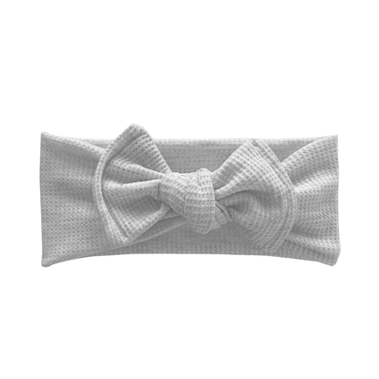 Light gray waffle top knot bow headband with a bow on a white background