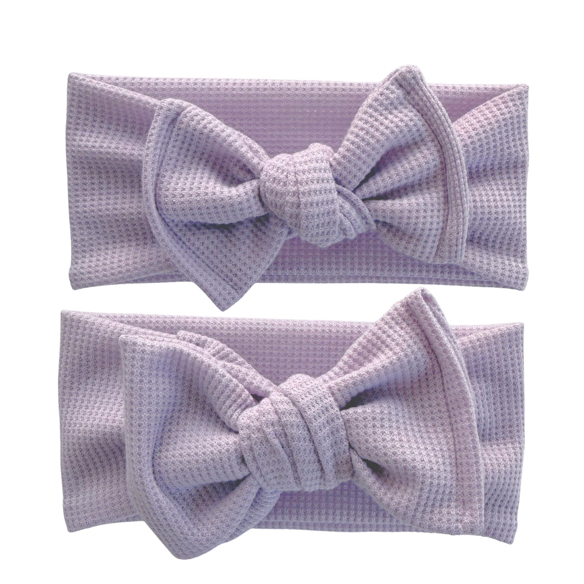 Two lavender textured headbands on a white background. Top is a top knot, bottom is an oversized bow.