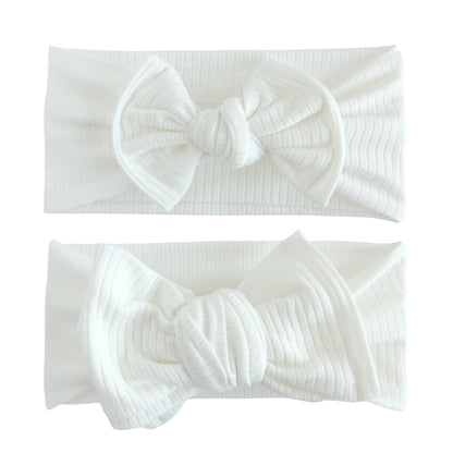 Baby girl headbands in top knot and oversized bow styles in white, made from cotton ribbed knit fabric