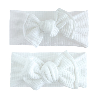 Baby girl headbands in top knot and oversized bow styles in white, made from ribbed knit fabric