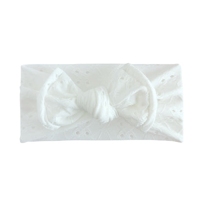 White lace headband with bow on a white background