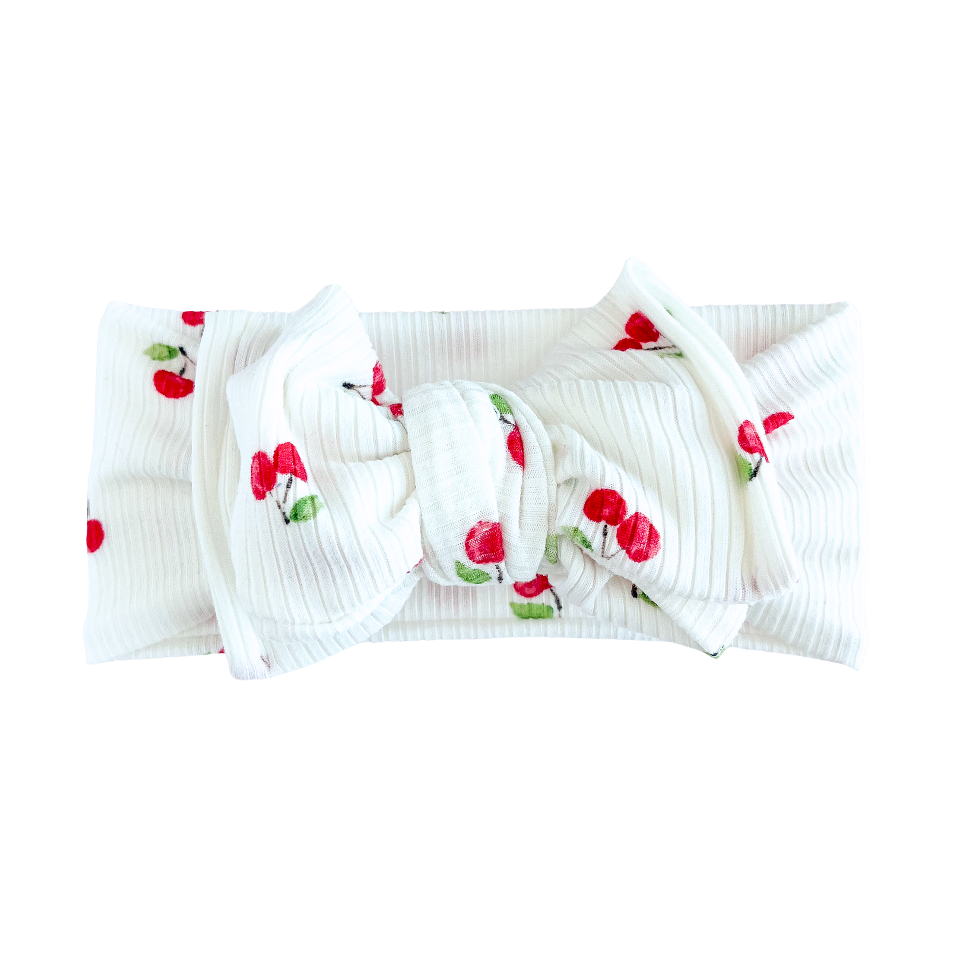 White ribbed knitted oversized bow headband with cherry pattern on a white background