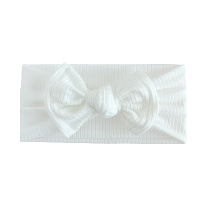 White ribbed top knot headband with white background.
