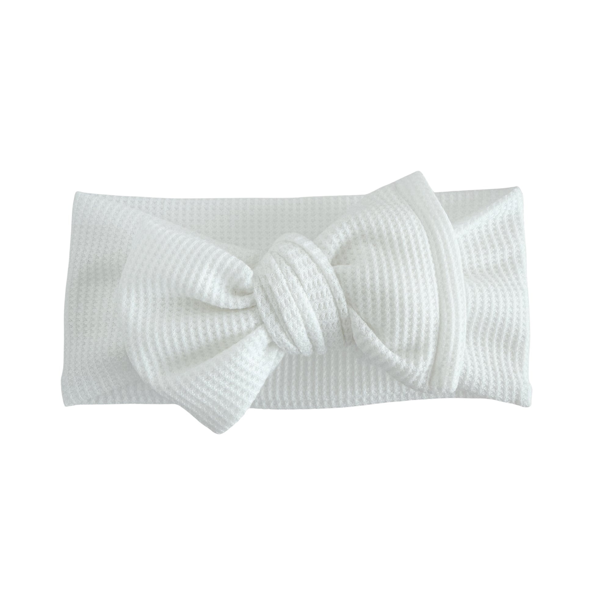Oversized bow baby headband in white, crafted from waffle knit fabric, displayed on a white background